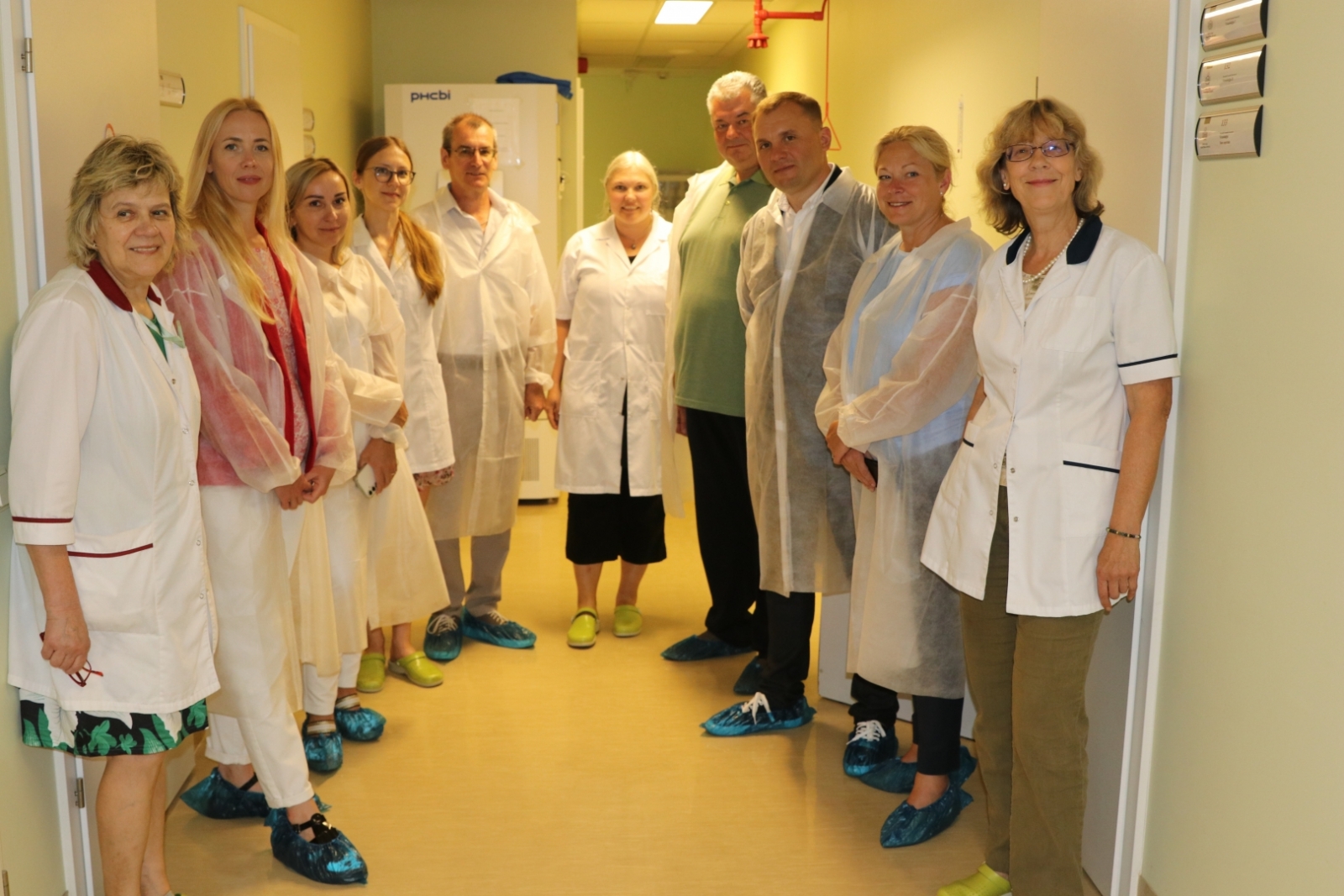 Grupas bilde Nacionālās fitosanitārās laboratorijas telpās, cilvēki baltos halātos